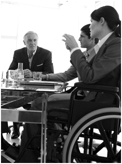 Person in a wheel chair speaking at a meeting